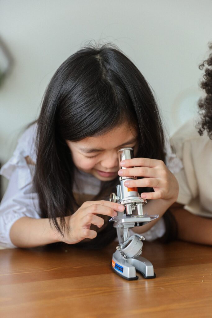 Girl looking into a microscope.